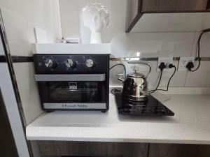 a tea kettle sitting on a stove in a kitchen at Indulge Deluxe Accommodation in Middelburg +20 photos