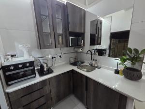 a kitchen with a sink and a microwave at Indulge Deluxe Accommodation in Middelburg