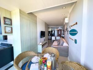 a dining room table with chairs and a living room at Frente mar na praia de Itaparica! in Vila Velha