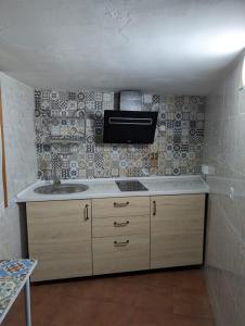 a kitchen with a sink and a tv on the wall at Apartamento Turístico Monteceli AT-CC-00748 in Gata