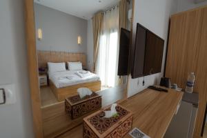 castello hotel في القاهرة: غرفة نوم بها سرير وتلفزيون بشاشة مسطحة