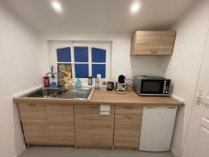 a small kitchen with a sink and a microwave at Un cocoon spacieux in Les Essarts-le-Roi