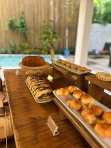 a table topped with trays of bread and pastries at Pousada Villa Gûyrá in Trancoso