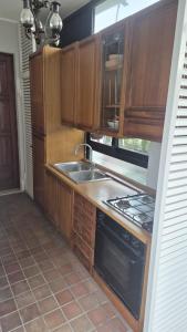 a kitchen with wooden cabinets and a sink and a stove at Dimora ANETT B&B HOUSE in Codevigo