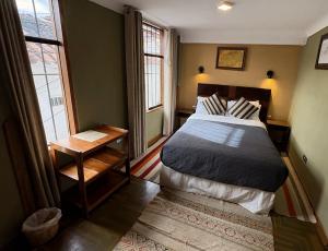a bedroom with a large bed and two windows at Eco Home View - Guest House in Cusco