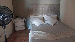 a bedroom with a bed with white pillows and a camera at Flat vista mar in Paulista