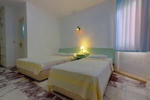 A bed or beds in a room at Mandalinn Hotel