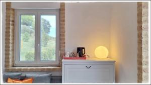 a window in a room with a table with a lamp at La Fonte e l Ulivo in Ripatransone