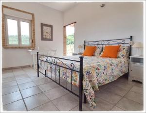 a bedroom with a bed with orange pillows at La Fonte e l Ulivo in Ripatransone