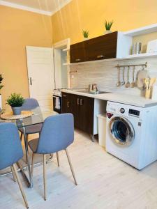 a kitchen with a washing machine and a table and chairs at Ostrava Apartment in Ostrava