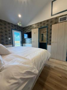 a bedroom with a large white bed in it at The Breeze Beachfront Resort in Surfside Beach