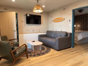 a living room with a couch and a table and a bed at The Breeze Beachfront Resort in Surfside Beach