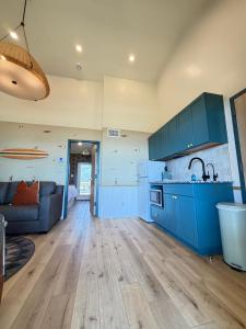 a kitchen with blue cabinets and a living room at The Breeze Beachfront Resort in Surfside Beach