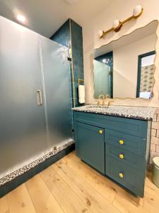 a bathroom with a blue cabinet and a shower at The Breeze Beachfront Resort in Surfside Beach +15 photos