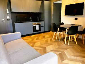 ein Wohnzimmer mit Sofa und einem Tisch mit Stühlen in der Unterkunft CEFALUX - Apartments Collection in Cefalú