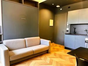 ein Wohnzimmer mit Sofa und eine Küche in der Unterkunft CEFALUX - Apartments Collection in Cefalú