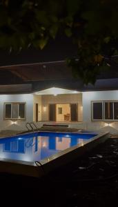 a large swimming pool in a house at night at Aarambh Villa in Sātirje