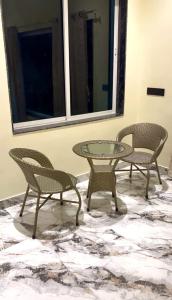 three chairs and a glass table in a room at Aarambh Villa in Sātirje
