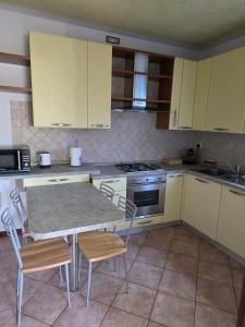 a kitchen with yellow cabinets and a table and chairs at Rolly Home - Verona Apartment in Verona