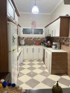 a kitchen with a white refrigerator and a checkered floor at spacious ground floor apartment in Taroudant