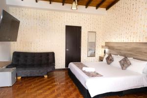 a bedroom with a large bed and a chair at Hotel Versalles Boutique in Pasto