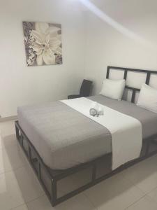 a bedroom with a large bed with white sheets at Plata View Center Habitacion 2D in Monte Plata