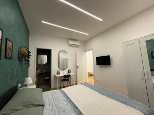 a bedroom with a bed and a desk and a mirror at Stay & Solution Apartment in Trieste