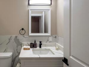 a white bathroom with a sink and a mirror at 4BR5BA Luxury World Cup hub in North Bergen +27 photos