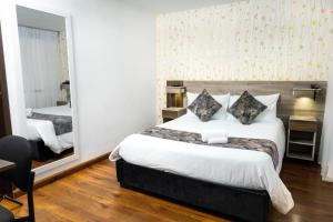 a hotel room with a large bed and a mirror at Hotel Versalles Boutique in Pasto +12 photos