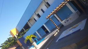 a building with a palm tree in front of it at Pousada Sol e Mar in Saubara +7 photos