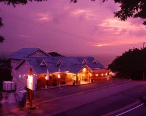 una casa illuminata di notte con luci di Rurika a Izu