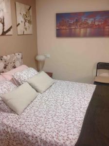 a bedroom with a bed with a white blanket at bonito estudio equipado in Alcorcón