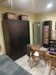 a bedroom with black cabinets and a table and a refrigerator at bonito estudio equipado in Alcorcón