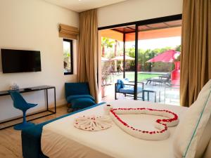 a hotel room with a bed and a view of a patio at Villa des iris Domaines NAJMA in Marrakesh