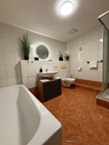 a bathroom with a tub and a sink and a toilet at MarktQuartier Bad Schandau in Bad Schandau +10 photos