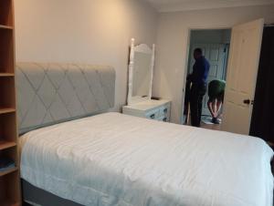 a man standing in a bedroom with a bed at Budget shared accommodation holiday room spring city in Tauranga