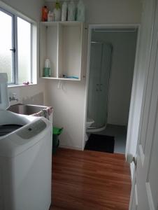a kitchen with a washing machine and a sink at Budget shared accommodation holiday room spring city in Tauranga