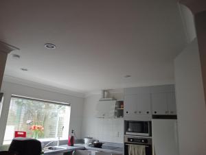 a white kitchen with a sink and a window at Budget shared accommodation holiday room spring city in Tauranga