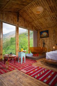 a bedroom with a tub and a bed and a table at Riad Atlas Bangalow in Imlil