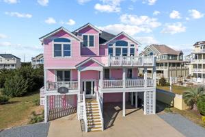 a pink house with a porch and a balcony at AV13 Time Away in Avon