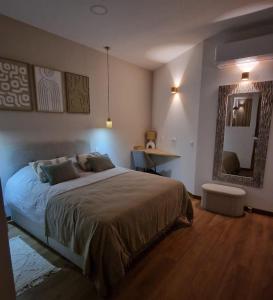 a bedroom with a large bed and a mirror at Sweet Apartment Aveiro Station in Aveiro