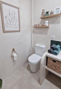 a bathroom with a toilet and a picture on the wall at Sweet Apartment Aveiro Station in Aveiro