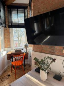 a kitchen with a table and a large flat screen tv at Apartments PSD - Filmowa in Słupsk