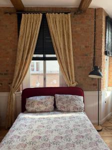 a bed in a bedroom with a large window at Apartments PSD - Filmowa in Słupsk