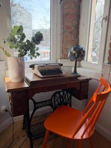 a desk with a keyboard and a chair in front of a window at Apartments PSD - Filmowa in Słupsk +6 photos