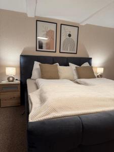 a bedroom with a large bed with two pictures on the wall at MarktQuartier Bad Schandau in Bad Schandau