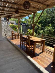 a wooden table and chairs on a wooden deck at La baxada mazunte in Mazunte