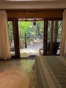 a bedroom with a large sliding glass door to a yard at La baxada mazunte in Mazunte