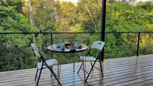 a table and two chairs on a deck with a view at Villas Pura Vida - Guapinol in Río Negro