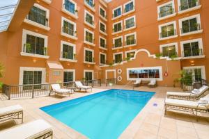 an apartment patio with a swimming pool in front of a building at iStay Hotel Ciudad Victoria in Ciudad Victoria